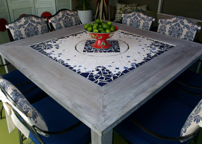 una mesa con una tapa de mosaico en el interior de la cocina