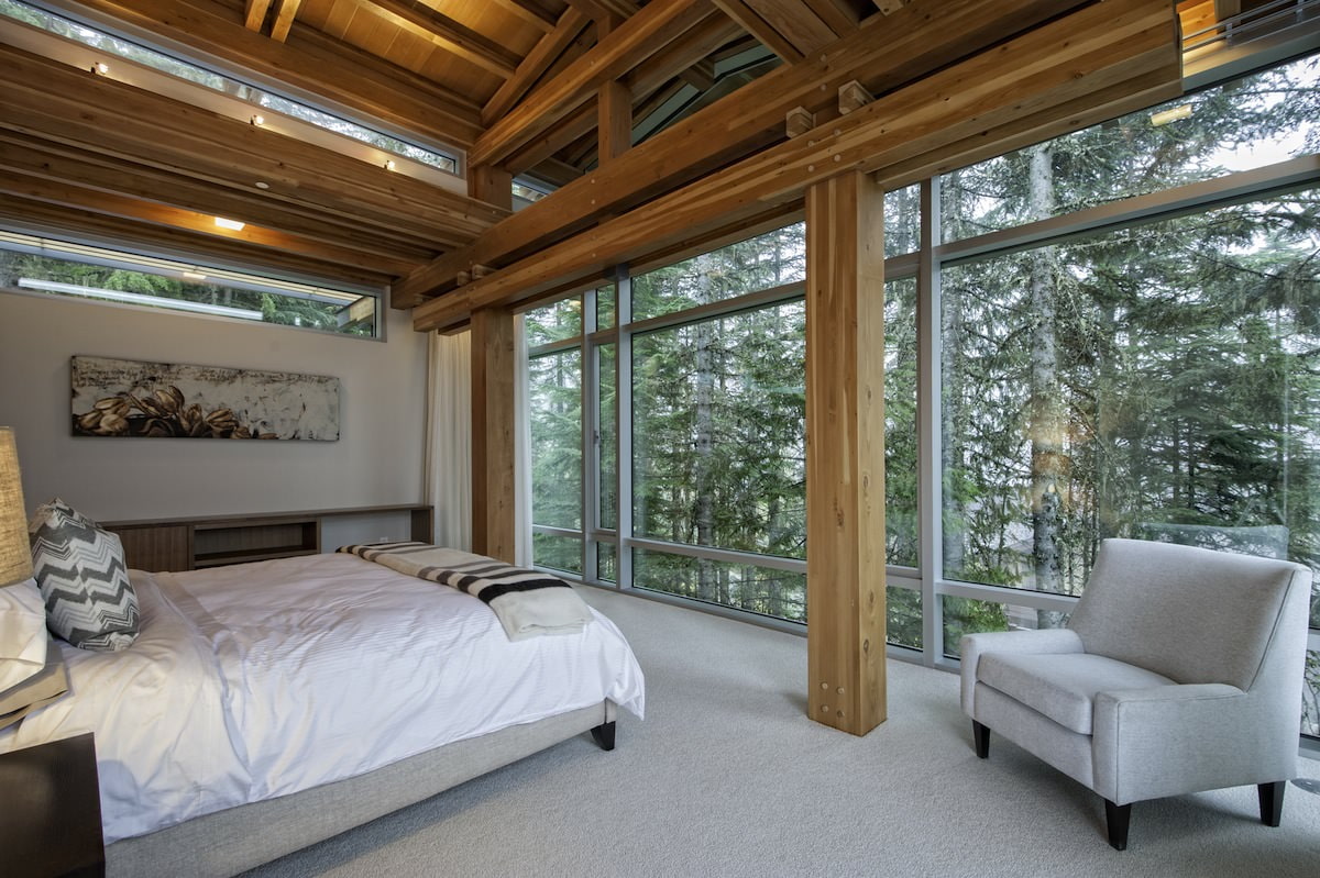 Interior de dormitorio en una casa de campo con ventanas panorámicas