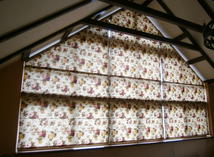 cortinas romanas en una ventana triangular