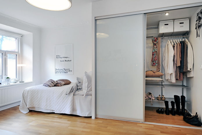 Vestidor con puertas brillantes en el interior del dormitorio.