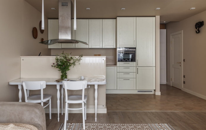 Cocina de madera blanca en un nicho en el interior.