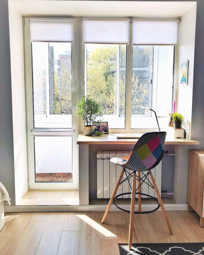 el alféizar de la ventana se convierte en una mesa con una mesa de madera