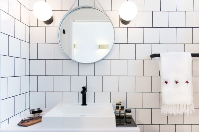 Azulejos blancos con lechada en el interior del baño.