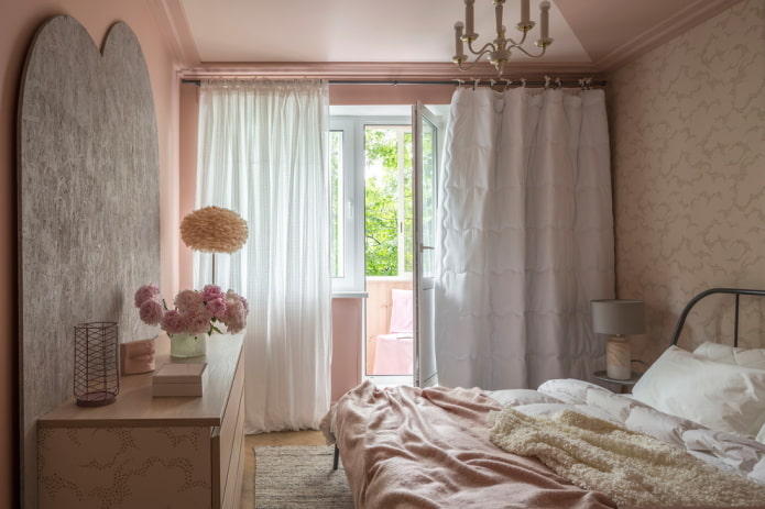 Interior del dormitorio en colores rosa y beige.