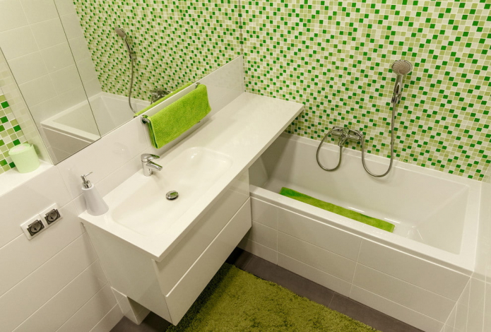 Interior blanco y verde de un pequeño baño.