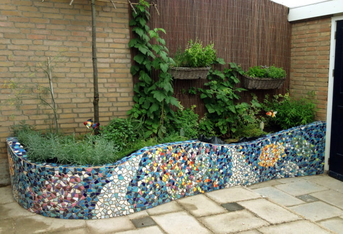 Decoración de macizo de flores con azulejos rotos.