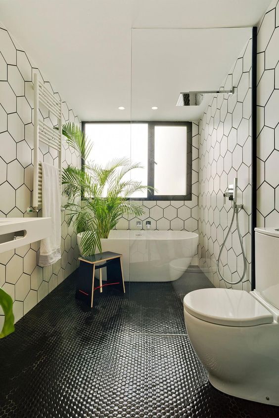 Baño blanco y negro con mosaico en el suelo.