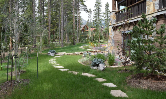 parterres de flores y un camino de jardín hecho de losas de piedra