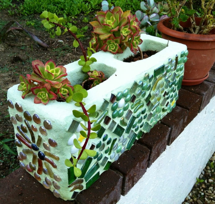 mini-macizo de flores hecho de un bloque de hormigón decorado con mosaico de vidrio