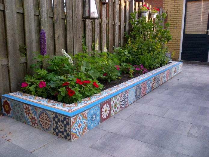 borde rectangular para un macizo de flores, forrado con azulejos de colores