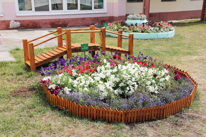 valla de madera marrón alrededor del macizo de flores