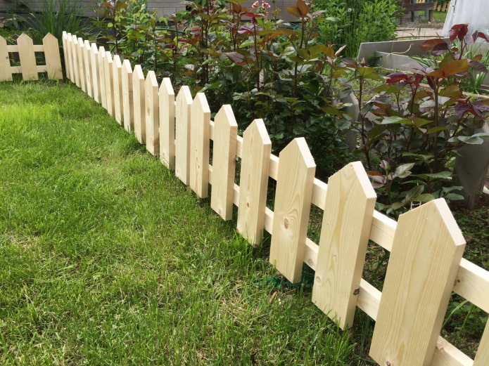 una cerca para un jardín de flores de tablas recién cepilladas