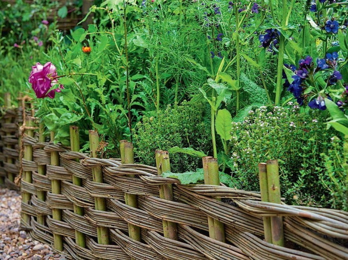 una cerca hecha de ramitas delgadas para un jardín de flores