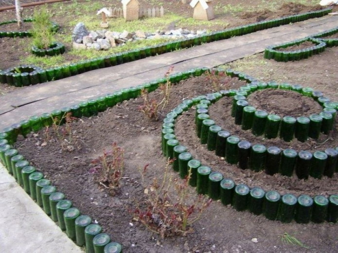 borde en forma de macizo de flores hecho de botellas de vidrio verde invertidas