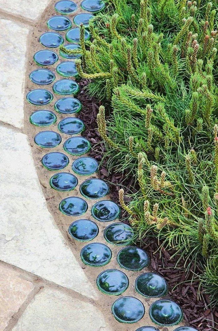 borde para un macizo de flores del fondo de botellas de vidrio incrustadas en cemento