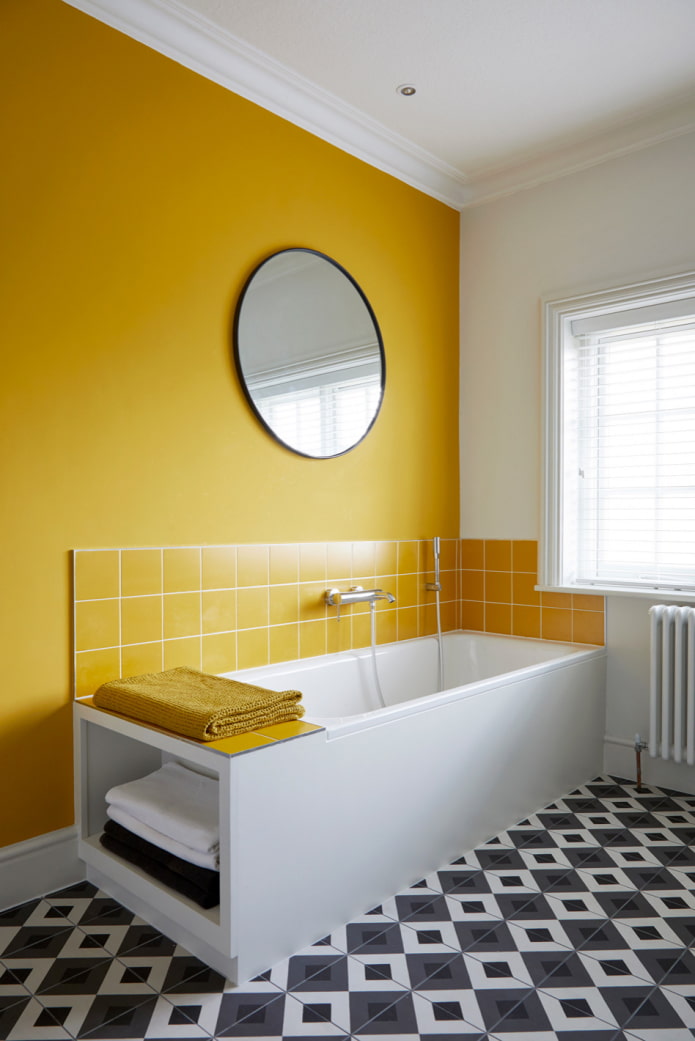 Baño con pared amarilla y piso de mosaico blanco y negro