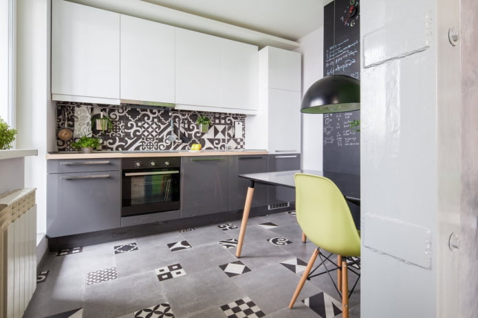 cocina gris y blanca con mosaico en el piso y en el delantal