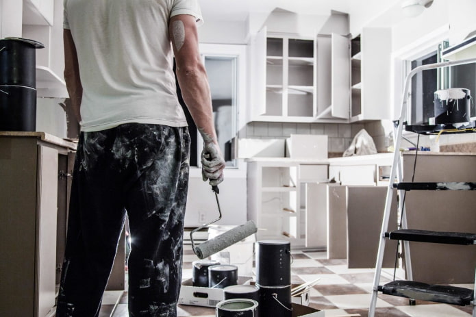 un hombre hace reparaciones en la cocina