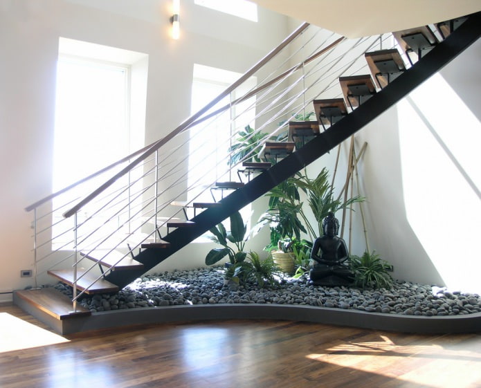 Jardín con piedras debajo del tramo de escaleras.